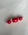 Broche rojo y piedras blancas